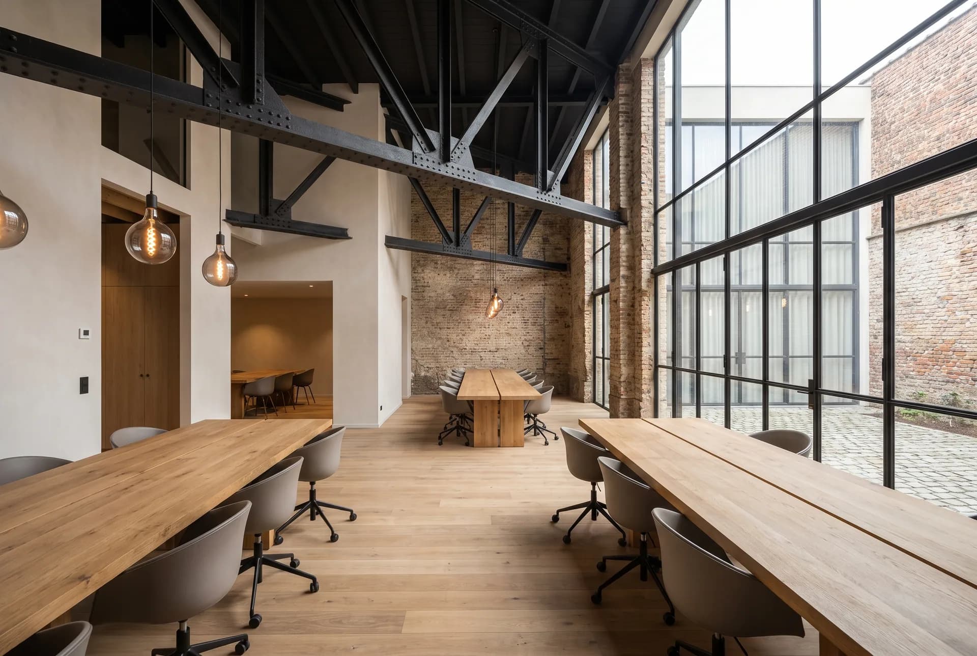Plateau de travail en double hauteur de l'Atelier Gand sous les fermes d'acier restaurées