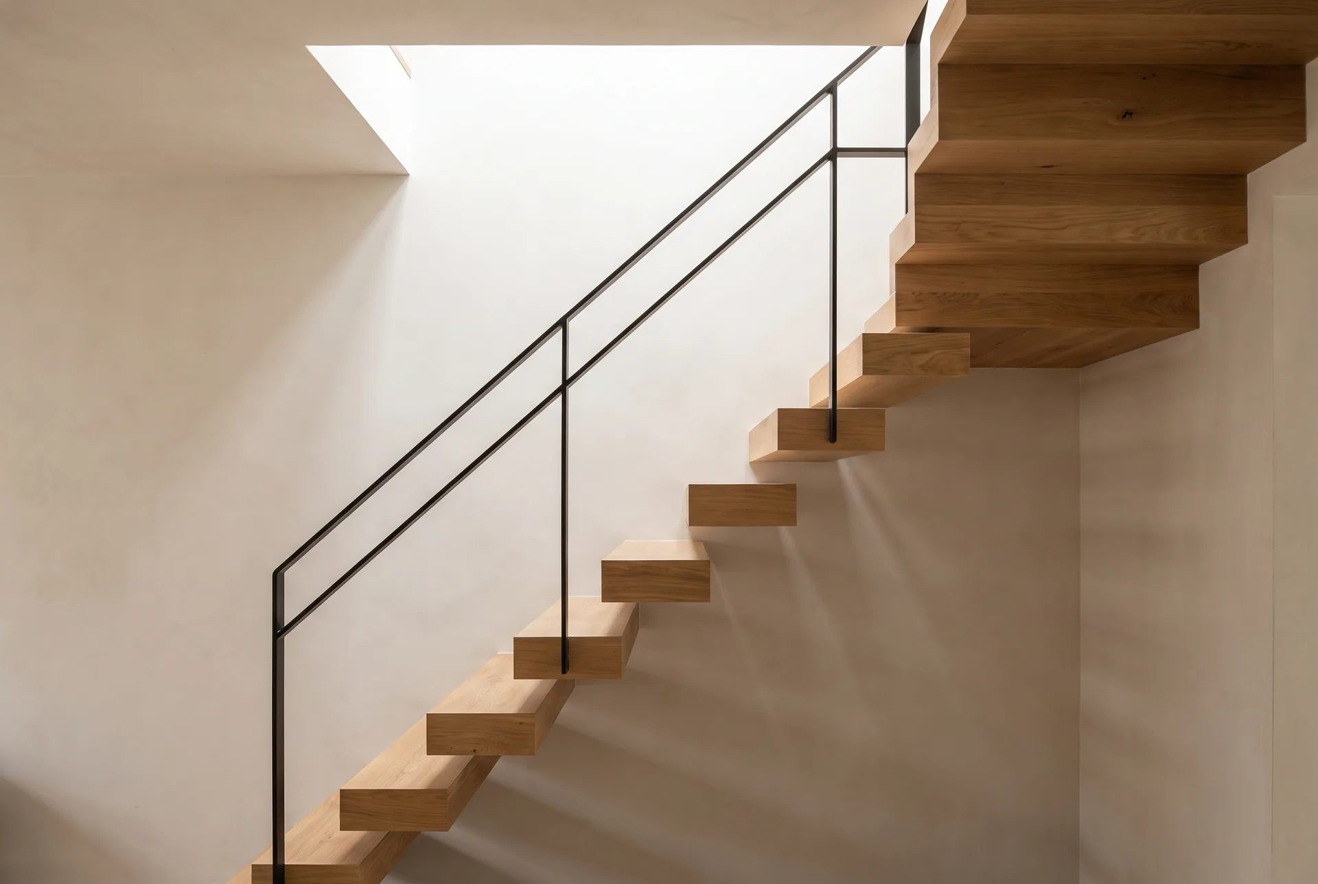 Escalier sculptural en chêne de la Maison M sous le puits de lumière