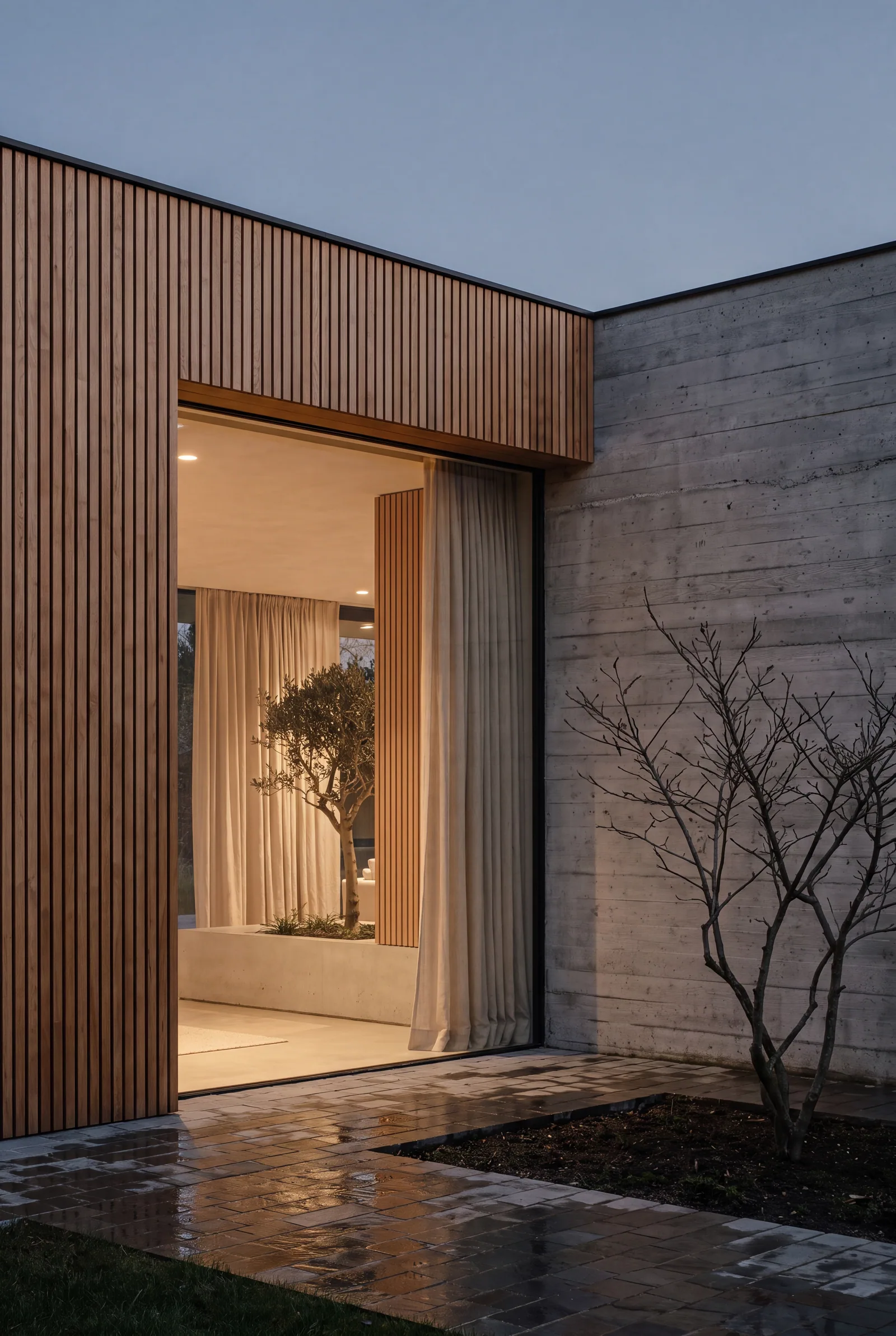 Détail de façade d'une villa contemporaine belge à la tombée du jour — bois de chêne, béton et baie vitrée